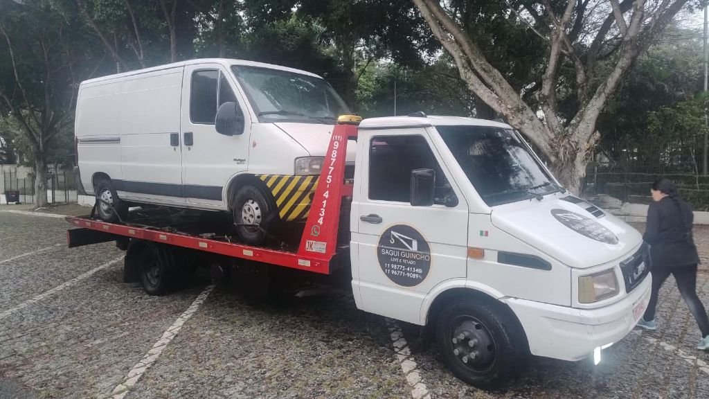 Van branca transportada pelo guincho da empresa